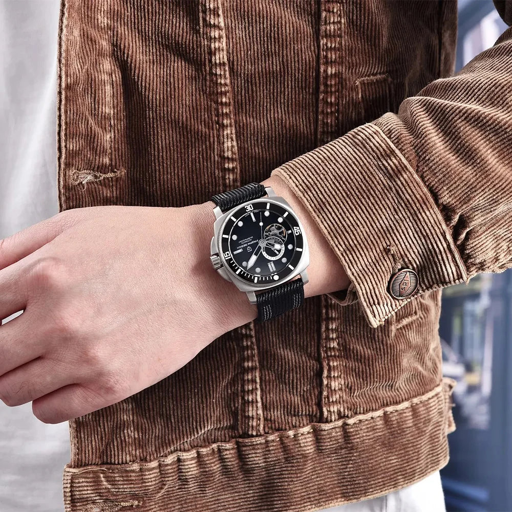 PAGANI DESIGN PD1736 open-heart automatic watch worn on wrist with black NATO strap, corduroy jacket sleeve